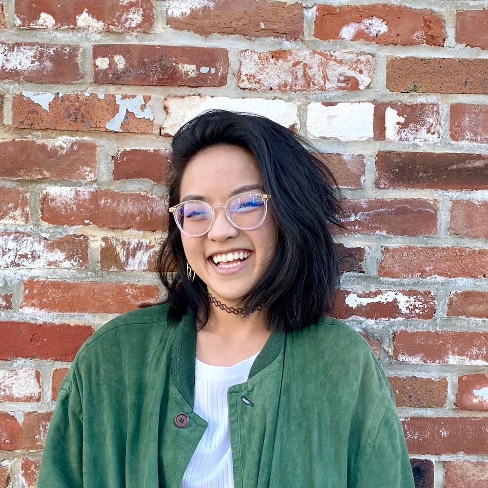 Angie Hoang standing in front of brick wall